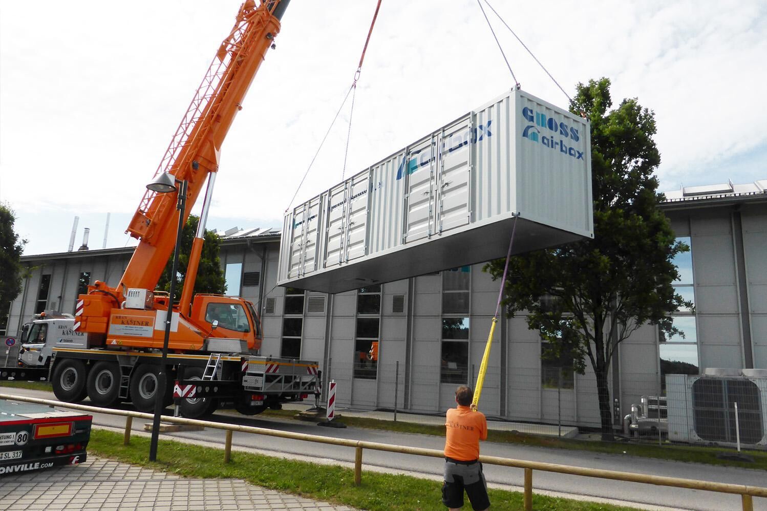 Montage eines Technikcontainers mit Kran an Industriegebäude durch Fachpersonal der GROSS GmbH, Teil des Airgroup-Verbunds - Drucklufttechniker in der Nähe - qualitätsgeprüfter Service - Wartung - Beratung und Versorgung rund um Industriekompressoren - Druckluft