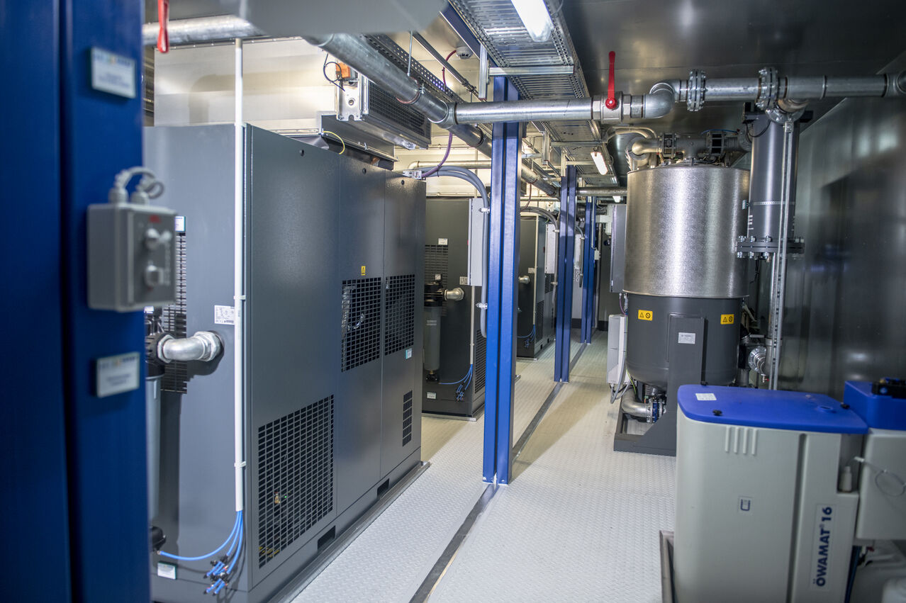 Innenansicht einer GROSS Airbox mit Kompressoren, Drucklufttechnik und Rohrleitungen – Airgroup Partner